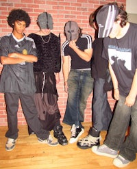 a group of people standing in front of a brick wall