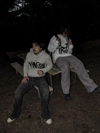 two men sitting on a picnic table